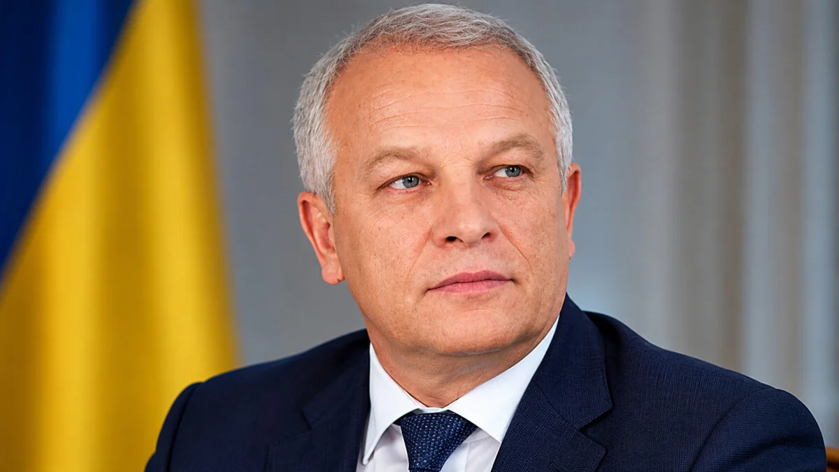 Степан Кубив в костюме на фоне флага Украины