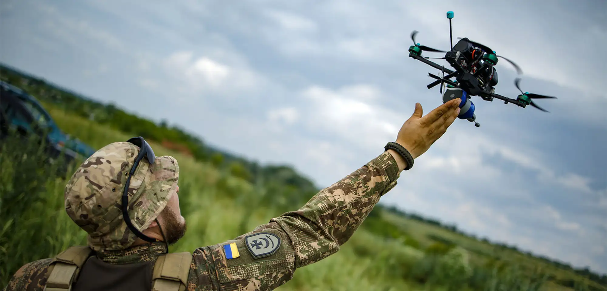 Український військовий тримає FPV-дрон на відкритому фронті
