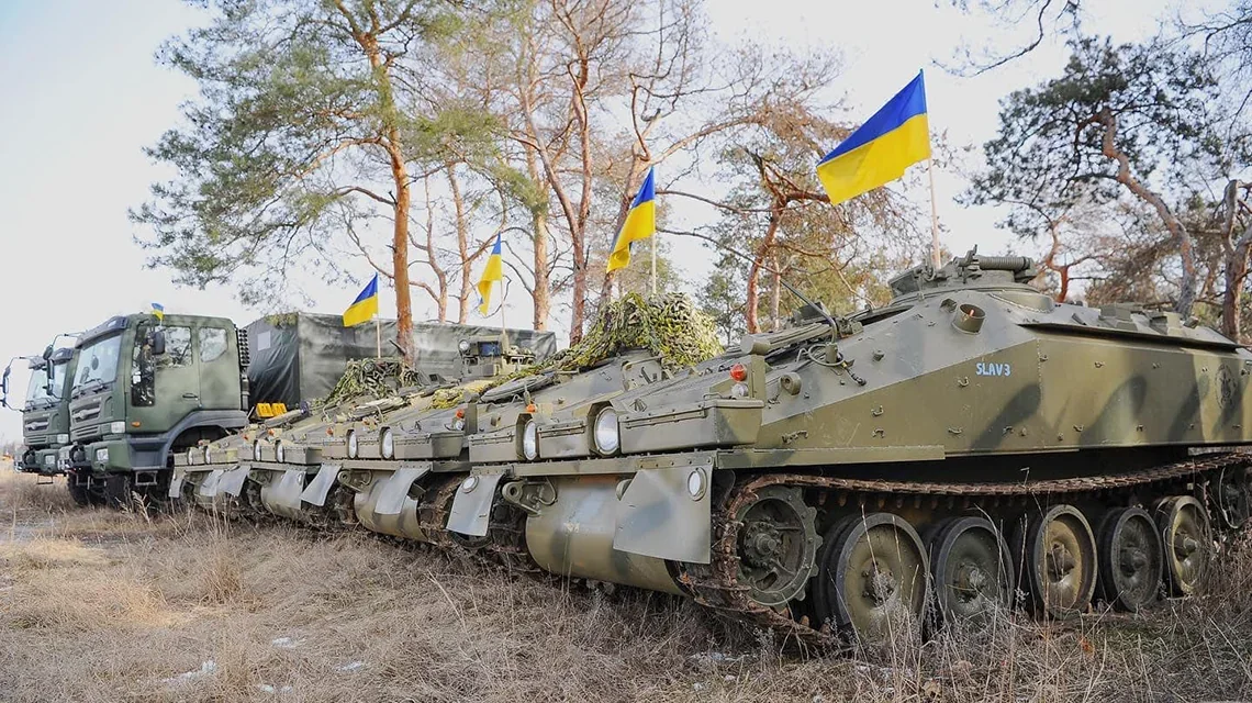 Бронемашини CVRT ЗСУ з прапорами України вишикувані в ряд на позиції
